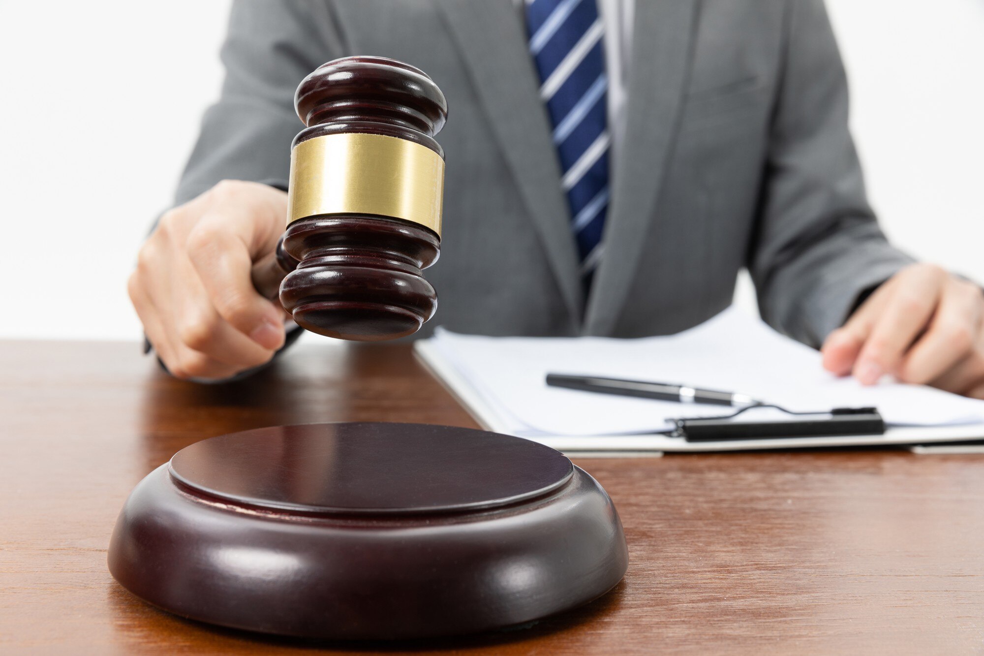 closeup shot person with gavel hand papers table 181624 47208